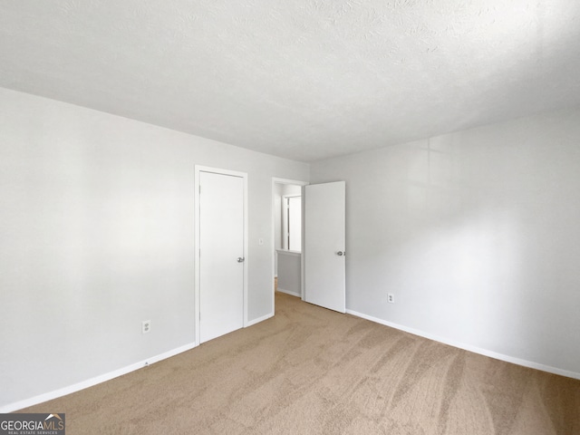 carpeted spare room with a textured ceiling