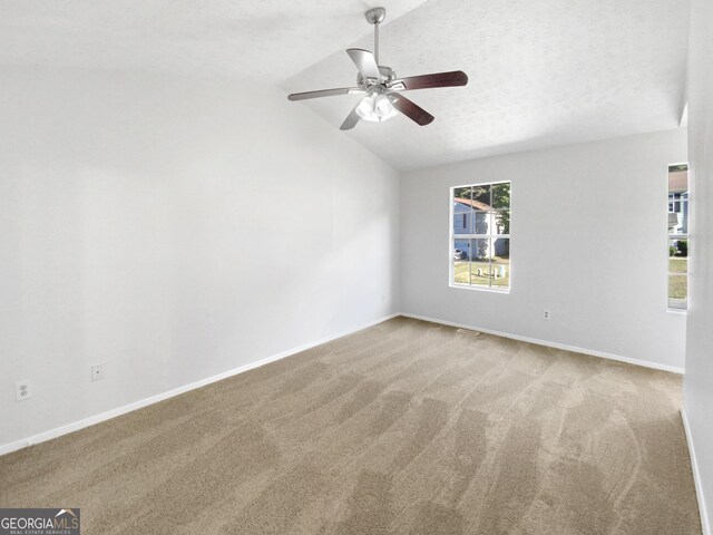 carpeted spare room featuring lofted ceiling, plenty of natural light, ceiling fan, and a textured ceiling