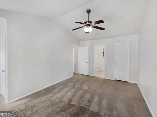 unfurnished bedroom with ceiling fan, connected bathroom, light carpet, and vaulted ceiling