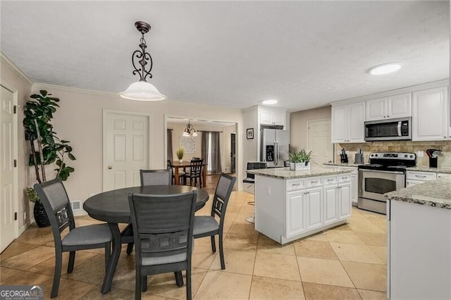 kitchen featuring appliances with stainless steel finishes, backsplash, a center island, and white cabinets