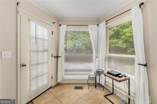 doorway to outside with visible vents, crown molding, and light tile patterned floors