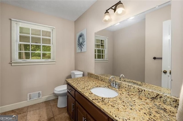 bathroom featuring baseboards, visible vents, toilet, tile patterned flooring, and vanity