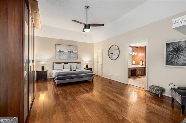 bedroom featuring connected bathroom, wood finished floors, a ceiling fan, baseboards, and visible vents