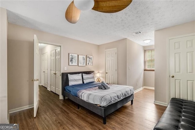 bedroom featuring visible vents, baseboards, and wood finished floors