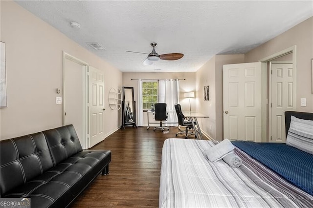 bedroom featuring visible vents, a ceiling fan, a textured ceiling, wood finished floors, and baseboards