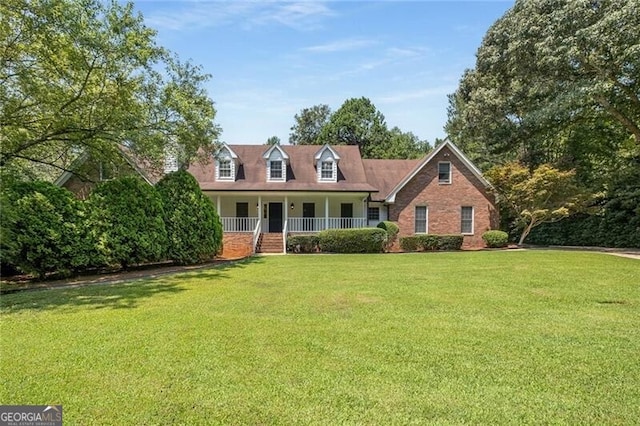 new england style home with covered porch and a front yard