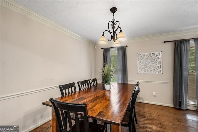 dining room featuring a chandelier, crown molding, baseboards, and wood finished floors