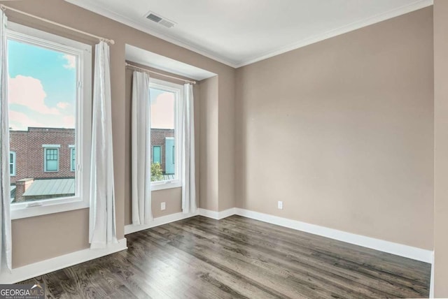 empty room featuring ornamental molding and dark hardwood / wood-style flooring