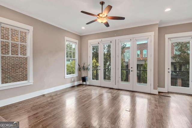 interior space with french doors, crown molding, wood-type flooring, and ceiling fan