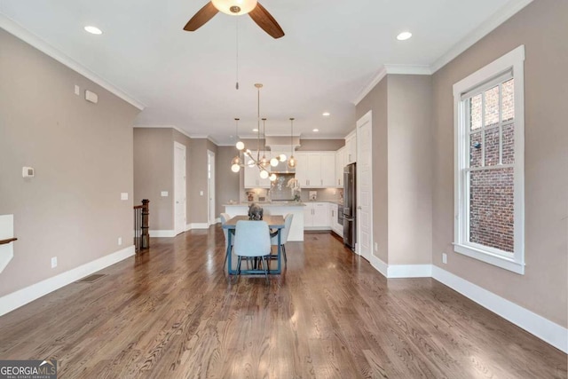 kitchen featuring dark hardwood / wood-style flooring, a center island, ornamental molding, and stainless steel refrigerator