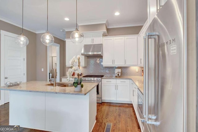 kitchen featuring light stone counters, white cabinets, appliances with stainless steel finishes, and hardwood / wood-style floors