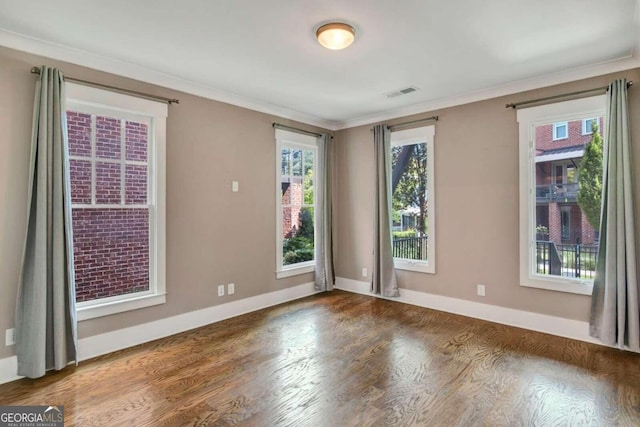 spare room with crown molding and dark wood-type flooring