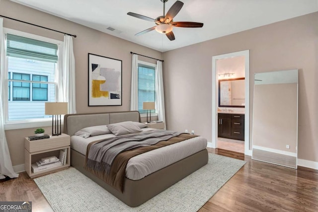 bedroom with wood-type flooring, ceiling fan, and ensuite bathroom