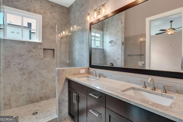 bathroom with ceiling fan, vanity, and a tile shower