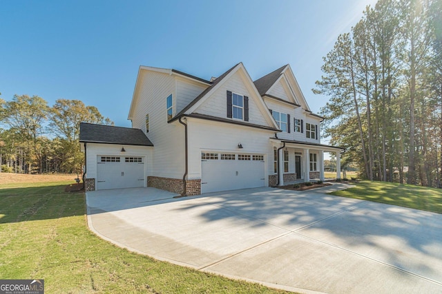 view of front of property with a garage, a front yard, and a porch