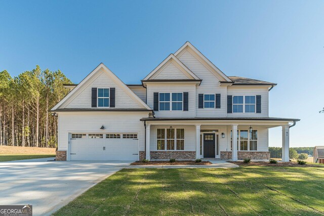 craftsman inspired home with a front lawn, covered porch, and a garage