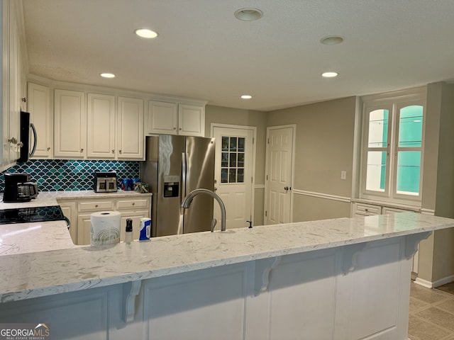 kitchen featuring white cabinetry, light stone countertops, and stainless steel appliances