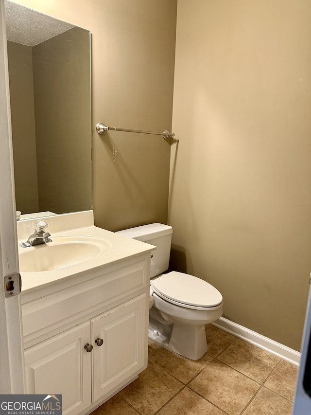 bathroom featuring vanity, a textured ceiling, toilet, and tile patterned floors