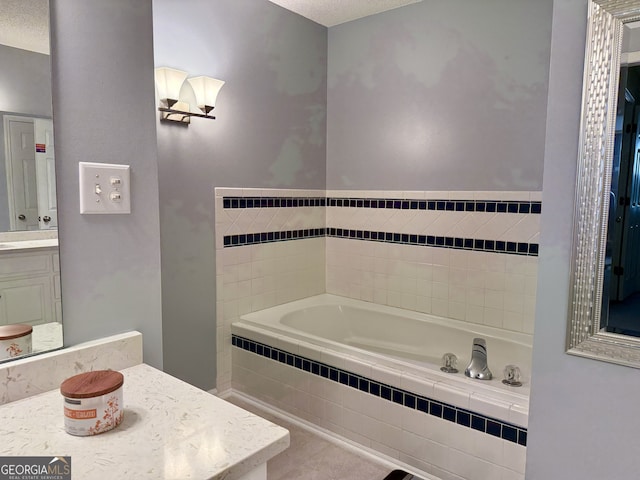 bathroom with vanity, a textured ceiling, tile patterned floors, and tiled bath