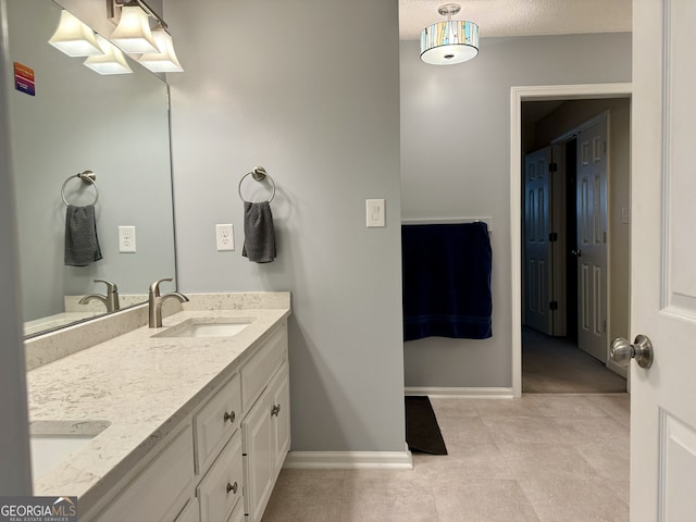 bathroom with vanity, a textured ceiling, and tile patterned flooring