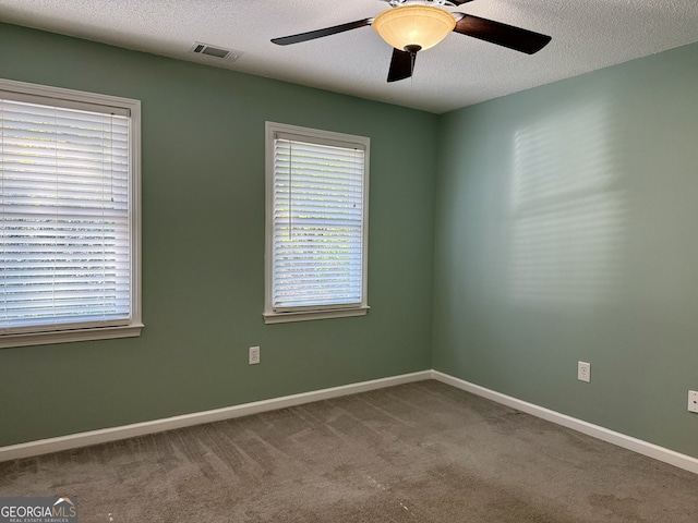 empty room with carpet flooring, a textured ceiling, and ceiling fan