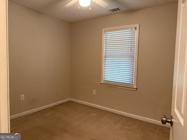 spare room featuring carpet flooring, a textured ceiling, and ceiling fan