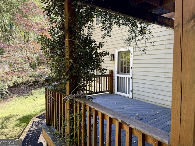 wooden terrace featuring a yard