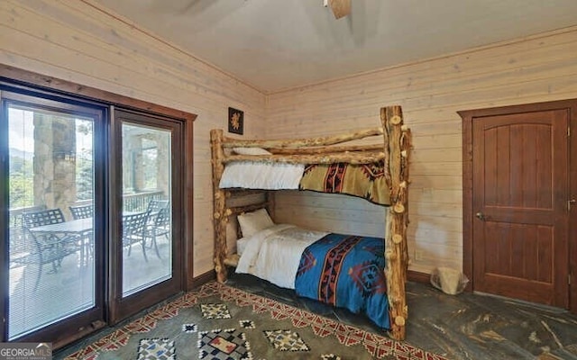 bedroom with access to outside, ceiling fan, and wood walls