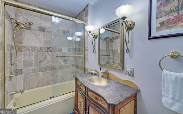 bathroom featuring combined bath / shower with glass door and vanity