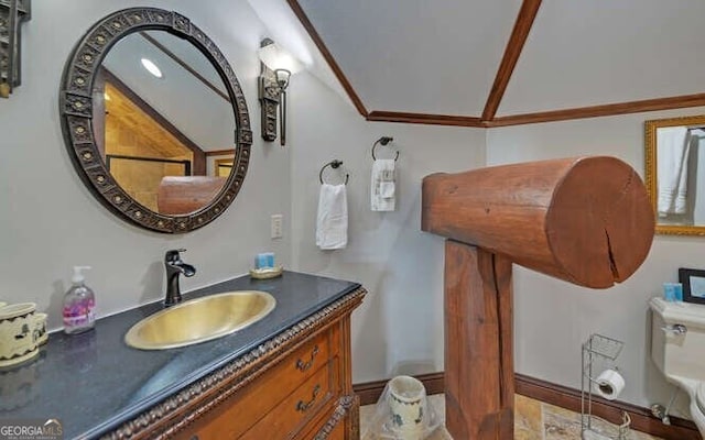 bathroom with vanity, toilet, ornamental molding, and vaulted ceiling