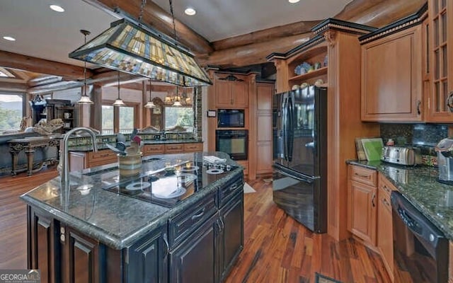 kitchen with black appliances, a kitchen island, dark hardwood / wood-style flooring, and a healthy amount of sunlight