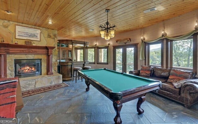 recreation room with french doors, a stone fireplace, wood ceiling, and billiards