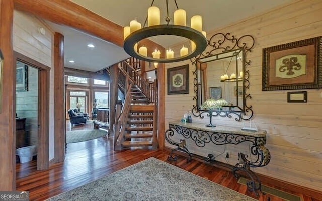 interior space with hardwood / wood-style flooring, wooden walls, and a chandelier