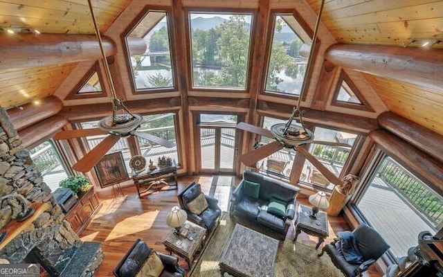 unfurnished living room with hardwood / wood-style flooring, ceiling fan, wooden ceiling, and rustic walls