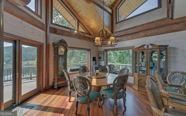 dining area with a healthy amount of sunlight, wooden ceiling, high vaulted ceiling, a notable chandelier, and hardwood / wood-style flooring