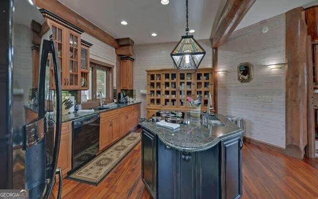 kitchen with black appliances, pendant lighting, dark stone countertops, dark hardwood / wood-style floors, and a kitchen island