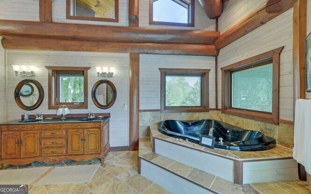 bathroom with a bathing tub, vanity, beam ceiling, and high vaulted ceiling