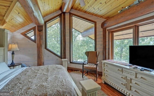 bedroom featuring hardwood / wood-style floors, wood ceiling, wooden walls, and vaulted ceiling