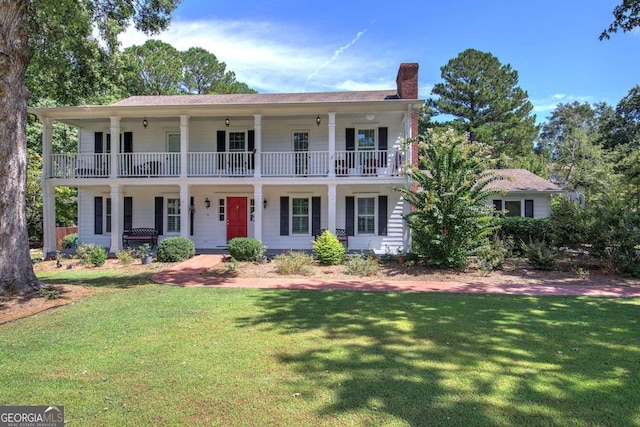 view of front of home with a front lawn and a balcony