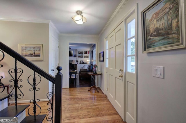 foyer with light hardwood / wood-style floors and crown molding