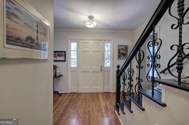 entryway featuring wood-type flooring and ornamental molding