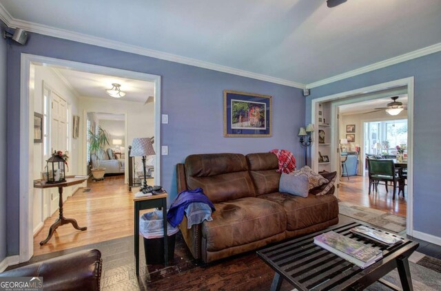 living room with ornamental molding, ceiling fan, and dark hardwood / wood-style floors