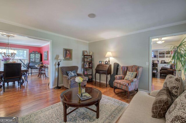 living room featuring hardwood / wood-style floors, crown molding, and a notable chandelier