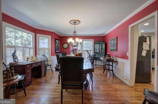 dining space with hardwood / wood-style flooring, a chandelier, and ornamental molding