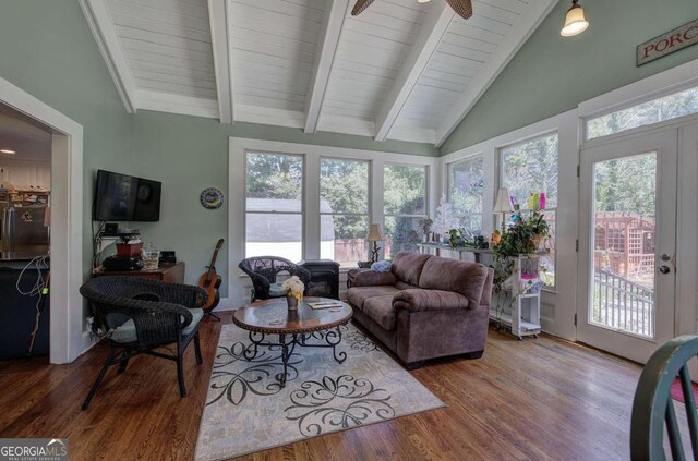 living room with a wealth of natural light, ceiling fan, beamed ceiling, and hardwood / wood-style flooring