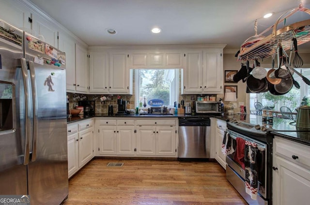 kitchen featuring white cabinets, appliances with stainless steel finishes, and light hardwood / wood-style flooring