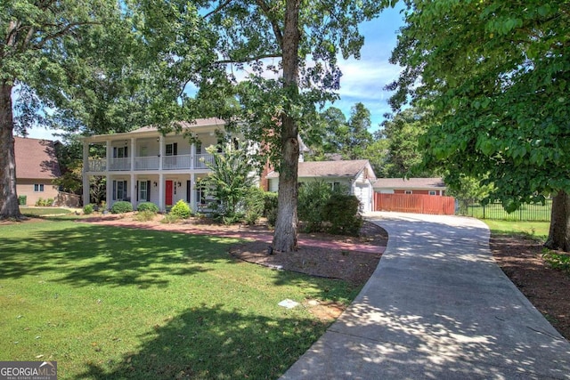 view of front of house with a balcony, a front yard, and a porch