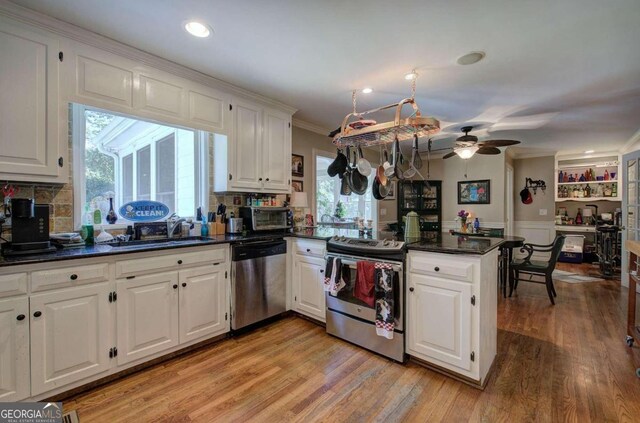 kitchen with appliances with stainless steel finishes, white cabinetry, and ceiling fan