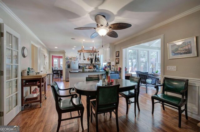 dining space with a wealth of natural light, ceiling fan, ornamental molding, and hardwood / wood-style floors