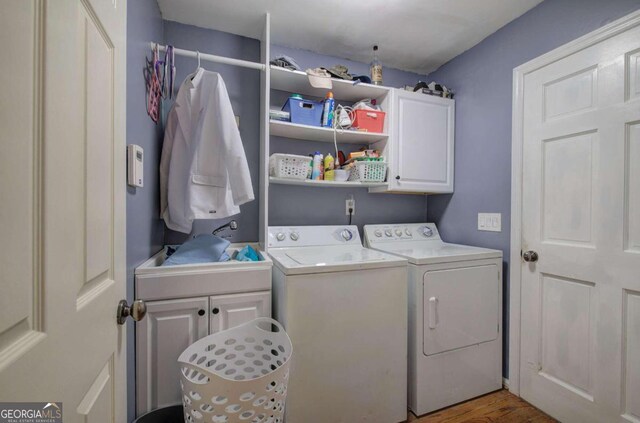 laundry room featuring cabinets, separate washer and dryer, and hardwood / wood-style floors